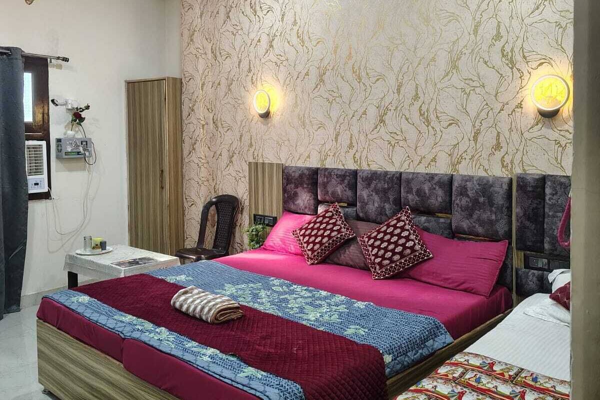 A bedroom with a large bed, two bedside tables, a ceiling fan, and patterned wallpaper.