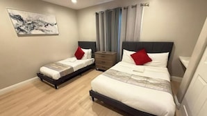 Un dormitorio con dos camas, un aparador y un cuadro en la pared.