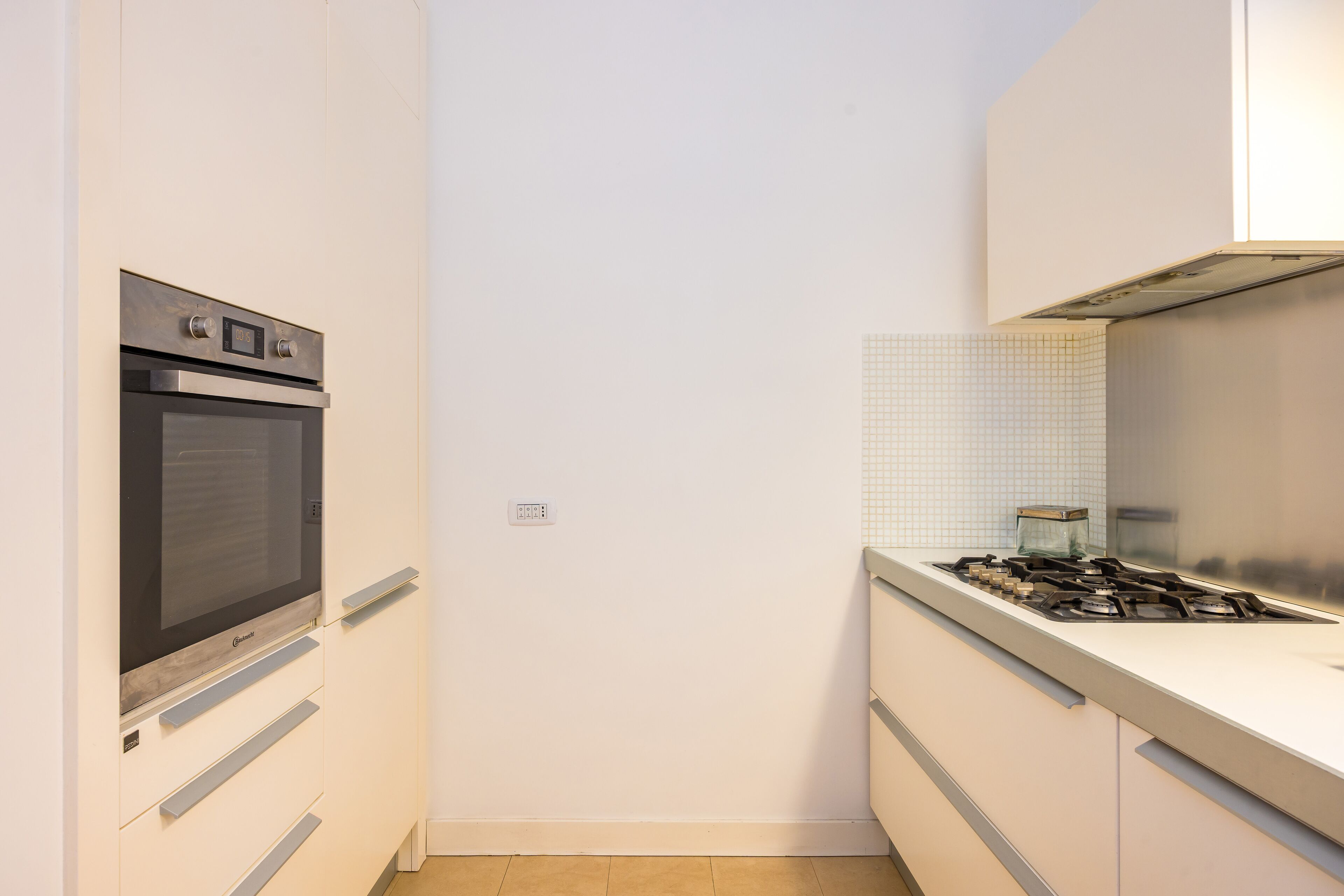 A compact kitchen with a built-in oven and a gas stove.