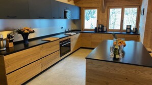 Una cocina moderna con armarios de madera, una isla central y un ventanal que proporciona luz natural.