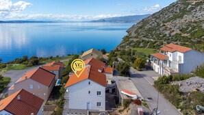 A coastal residential area with houses, a road, and a body of water. - Charming Senj by Villas Guide (Senj)