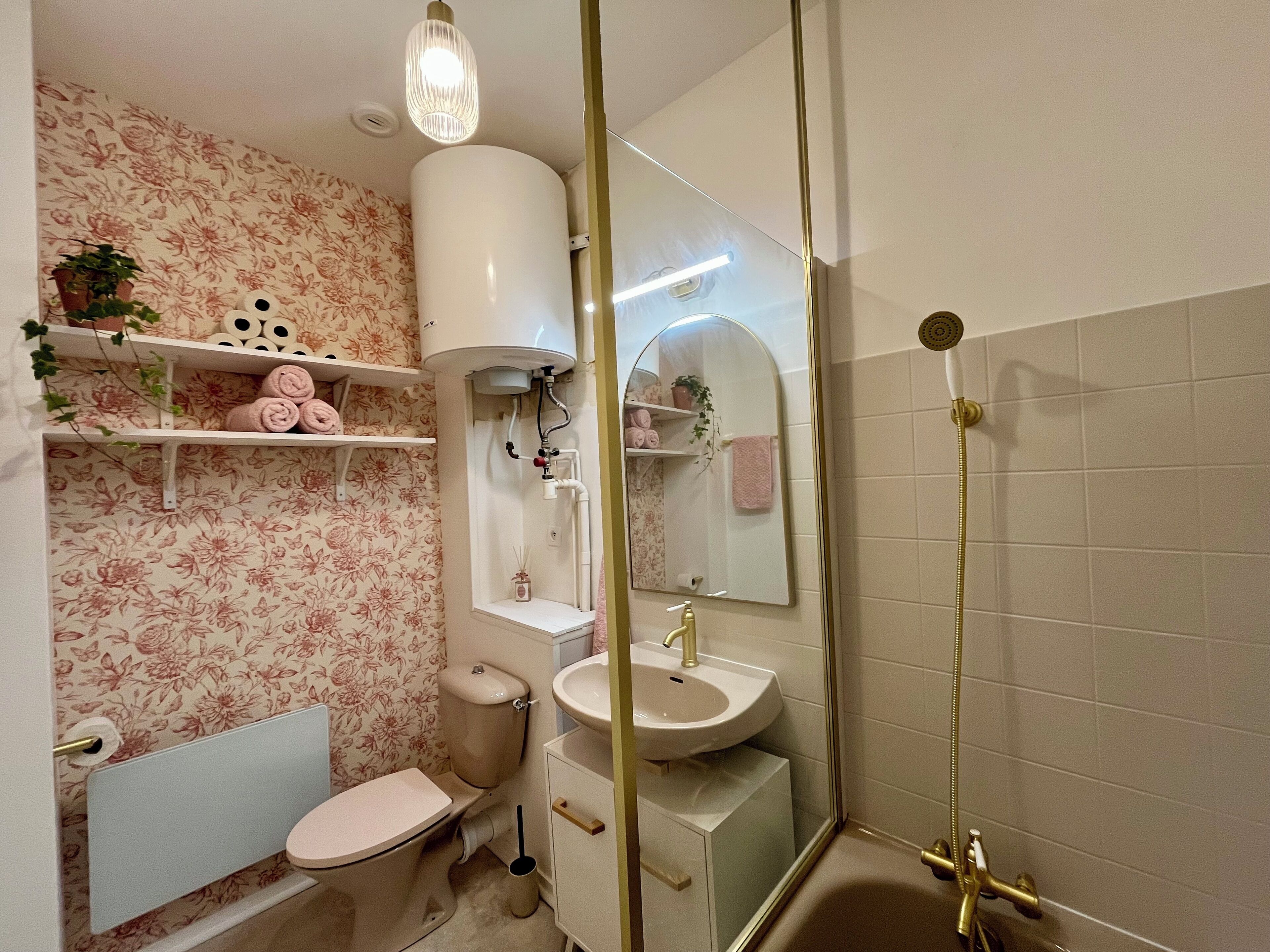 Een badkamer met toilet, wastafel, douche en spiegel.