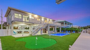 A two-story house with a pool, a covered patio, and a well-maintained lawn. - Saltwater Social ~ Game Room ~ Pool ~ Dock ~ Views (Marathon)