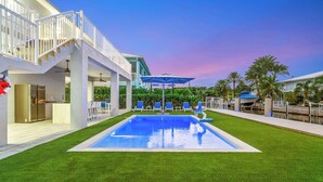 A swimming pool with a deck, a covered seating area, and a staircase leading to an upper level. - Saltwater Social ~ Game Room ~ Pool ~ Dock ~ Views (Marathon)