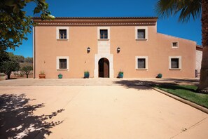 A two-story building with a symmetrical facade, a central entrance, and evenly spaced windows. - Exclusive Mallorcan finca with new house, pool and views of the countryside (PM)