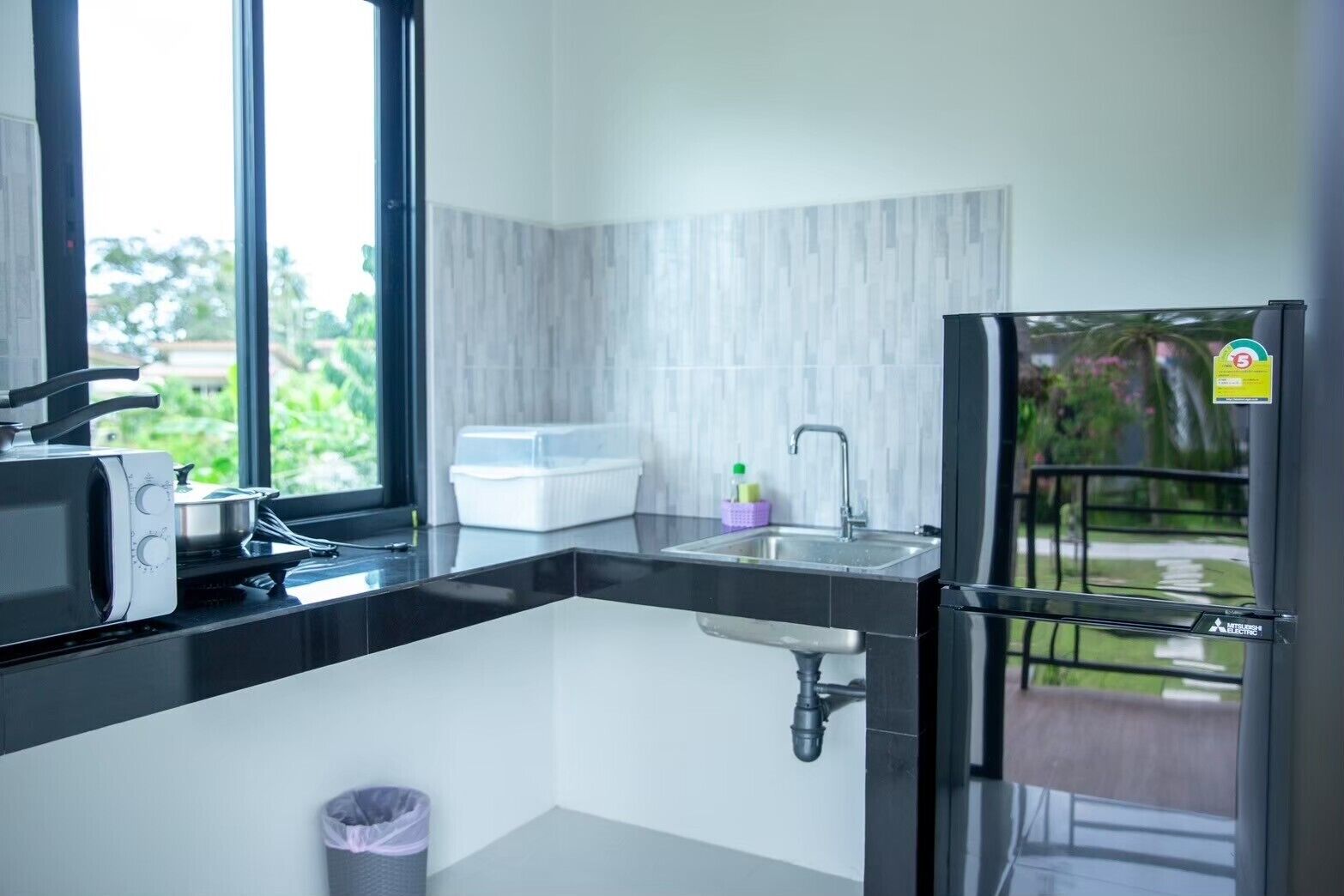 A modern kitchen with a microwave, sink, and refrigerator.