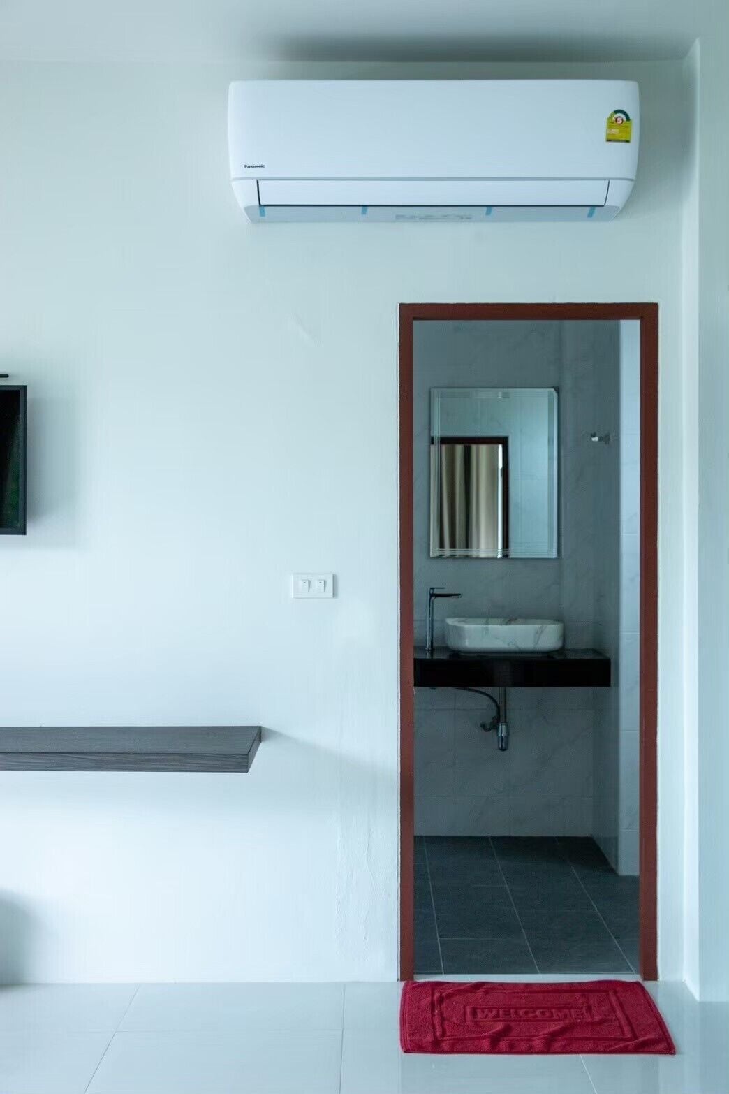 Un baño moderno con lavamanos integrado, espejo y retrete.