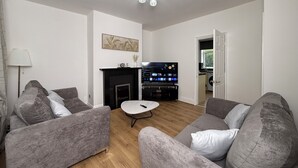A living room with grey sofas, a fireplace, a flat-screen TV, and a ceiling light fixture. - Urban Calm – Spacious 3-Bed Home with Free Parking
• Self Check-In (Rawmarsh)