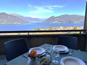 A table set for dining with a view of a lake and mountains. - Graziella 1 Apartment with a View of the Lake (Germignaga)