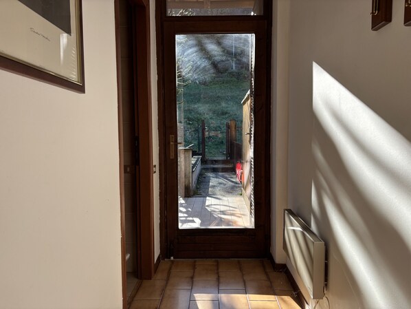 A hallway with a wooden door leading to an outdoor area. - Graziella 1 Apartment with a View of the Lake (Germignaga)