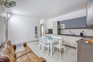 Un apartamento moderno con zona de comedor, cocina y sala de estar.