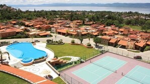 A resort with a swimming pool, tennis courts, and a view of the sea. - (Chapala)