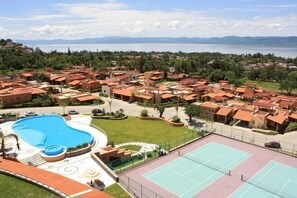 Un complexe hôtelier doté d’une piscine, de courts de tennis et offrant une vue sur la mer.