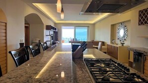 A modern kitchen with a central island, built-in appliances, and a view to the outdoors. - ANANA El Dorado 203 Condo with Lake views & Pool (Chapala)