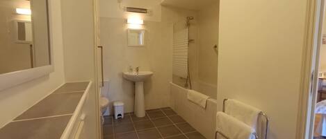 A bathroom with a sink, mirror, and shower.