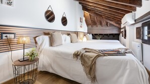 Quarto com cama, luminária de cabeceira, obra de arte na parede e ventilador de teto.