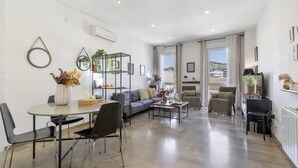 Un salon moderne comprenant un coin repas, un canapé, une table basse et une bibliothèque.