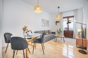 Ein modernes Wohnzimmer mit Esstisch, Stühlen, einer Couch und einer Lampe.