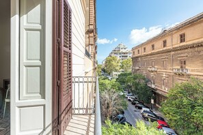 A view from a balcony overlooking a street with parked cars and buildings. - Central City Apartment by Wonderful Italy (Palermo)