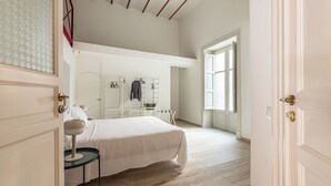 A bedroom with a bed, a bedside table, a wardrobe, and a window. - Central City Apartment by Wonderful Italy (Palermo)