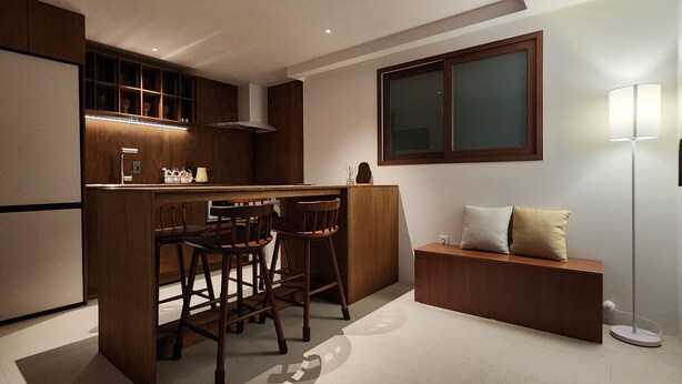 A modern kitchen with a bar area, wooden chairs, a built-in oven, and a large window. - Cozy Café Vibes & Timeless Design — Your Tranquil Seoul Hideaway Awaits (Seoul, , Yongsan-gu)
