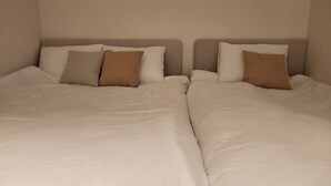 A double bed with white bedding and two pillows, one brown and one beige. - Cozy Café Vibes & Timeless Design — Your Tranquil Seoul Hideaway Awaits (Seoul, , Yongsan-gu)