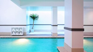 A swimming pool with a tiled edge, a potted plant, and a shelf with rolled towels. - Steps from Galleria Dallas + Dining. Pool. Gym. (Dallas)