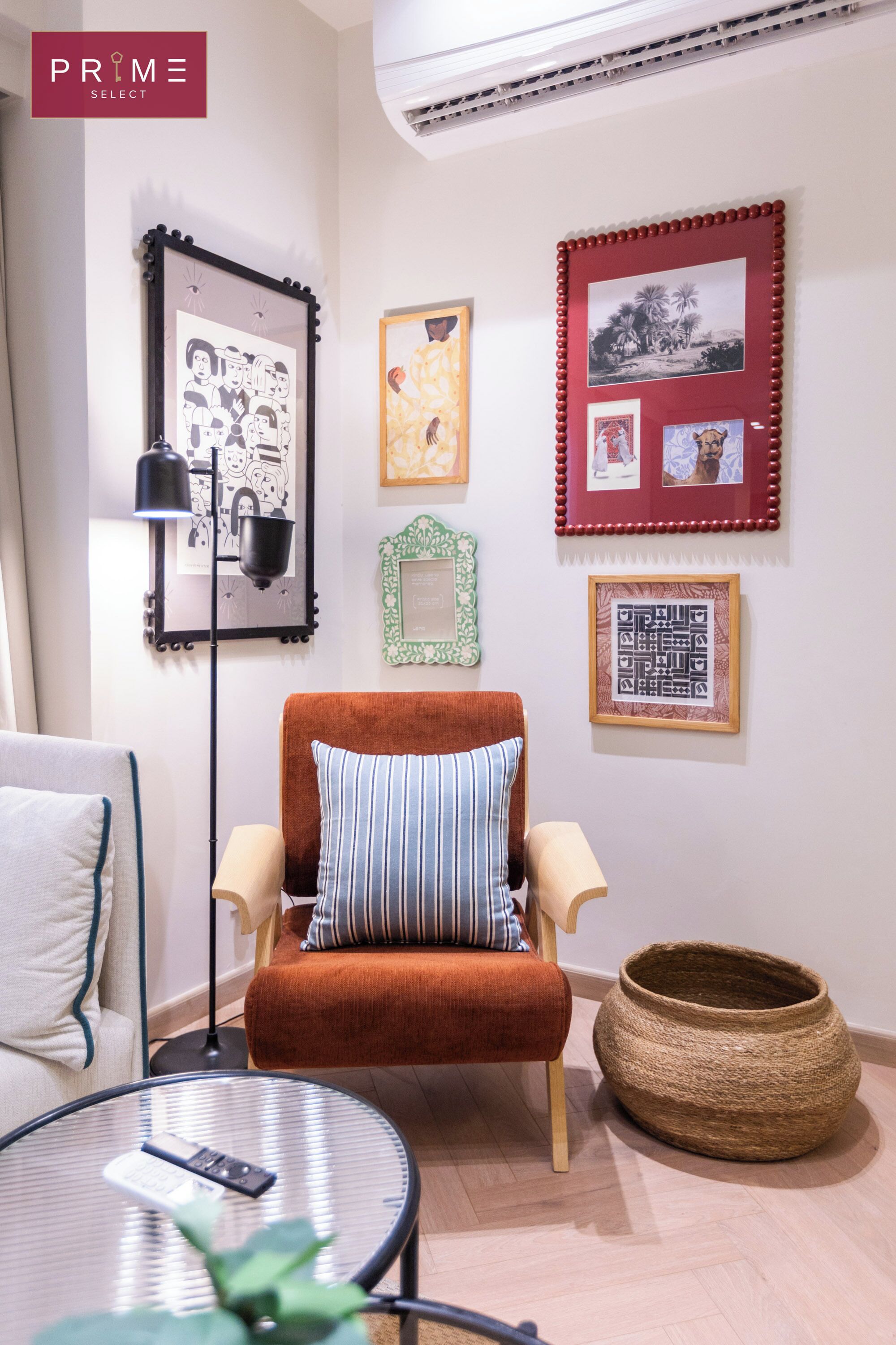 Una sala moderna con un sillón marrón, una mesa de centro redonda y una lámpara de pie.