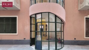 Une entrée d’angle avec une porte en verre incurvée, un extincteur et une enseigne indiquant « PRIME SELECT ».