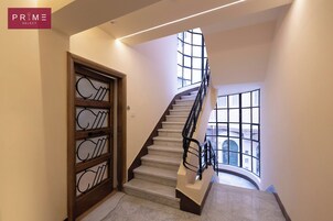 Una escalera moderna con barandilla de vidrio que lleva a un segundo piso.