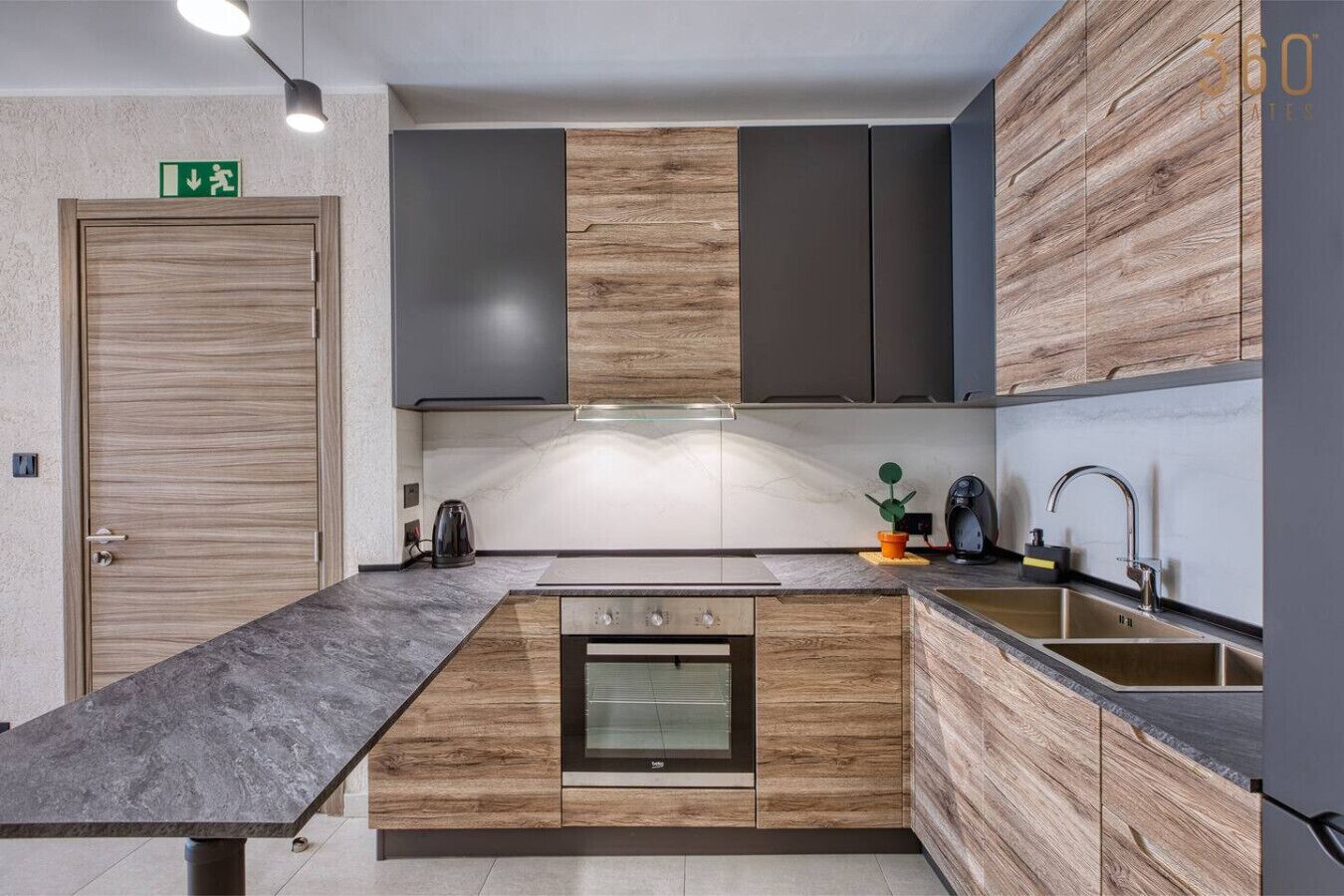 A modern kitchen with a central island, built-in cabinets, and a stainless steel sink.