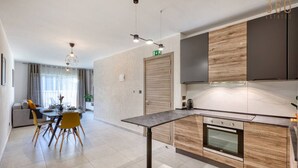 A modern kitchen with a central island, built-in appliances, and a dining area with a table and chairs. - Central 2BR Home in Pieta`s Heart w/Wifi & AC ! (Pietà)