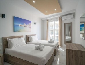 A hotel room with two beds, a large window, and a painting of a coastal scene. - A lovely 1BR seafront apartment with strong WIFI ! (St. Paul`s Bay)
