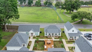 Zona residencial con casas, un gran campo verde y un campo de béisbol.