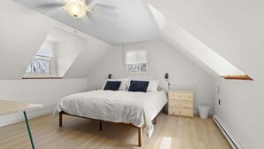 A bedroom with a bed, a desk, a chair, a ceiling fan, and a window. - Beach & Comfort | La Trappe a Houmard (Pointe-du-Chêne)