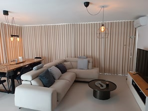 Ein modernes Wohnzimmer mit einer Eckcouch, einem Esstisch und einem Couchtisch.