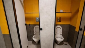 A men's restroom with two toilets, each with a separate partition. - Travelers Hostel  (Guwahati)