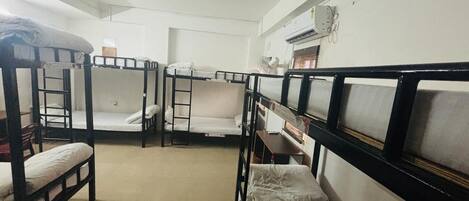 Ein Schlafsaalzimmer mit Etagenbetten, einem Schreibtisch und einem Stuhl.