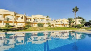 Ein Hotel mit großem Pool, mehreren Gebäuden und Palmen.