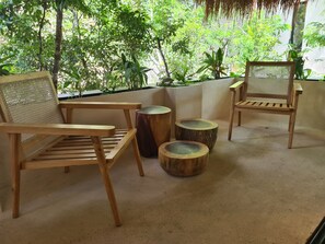 A wooden chair with a woven backrest and a matching wooden table, accompanied by two round stools with a natural finish. - Private Pool and Jacuzzi Penthouse S6 (Tulum)