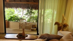 Una habitación con cama, una silla, una mesa y vistas a zonas verdes.