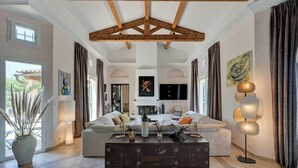 A spacious living room with a high ceiling, a fireplace, and a large sofa set. - La Villa Kef (Mallemort)