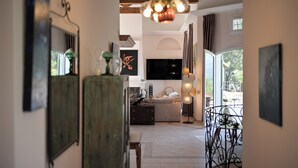 A spacious living area with a large TV, a dining table, and a view of the outdoors. - La Villa Kef (Mallemort)