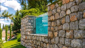 A stone wall with a glass window. - Horizon Villa Luxurious Lakefront Retreat (Shkodër)