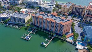 An aerial view of a coastal hotel with multiple buildings, a marina, and a pool area. - Waterfront 3B Balcony Hot Tub Pool Near Beach (Clearwater Beach)