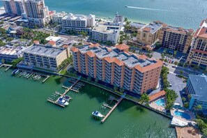 An aerial view of a coastal hotel with multiple buildings, a marina, and a pool area. - Waterfront 3B Balcony Hot Tub Pool Near Beach (Clearwater Beach)