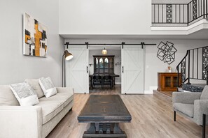 A spacious living area with a sofa, a coffee table, and a dining table. - Luxury Hilltop Designer House w Pool Great Views (Hacienda Heights)