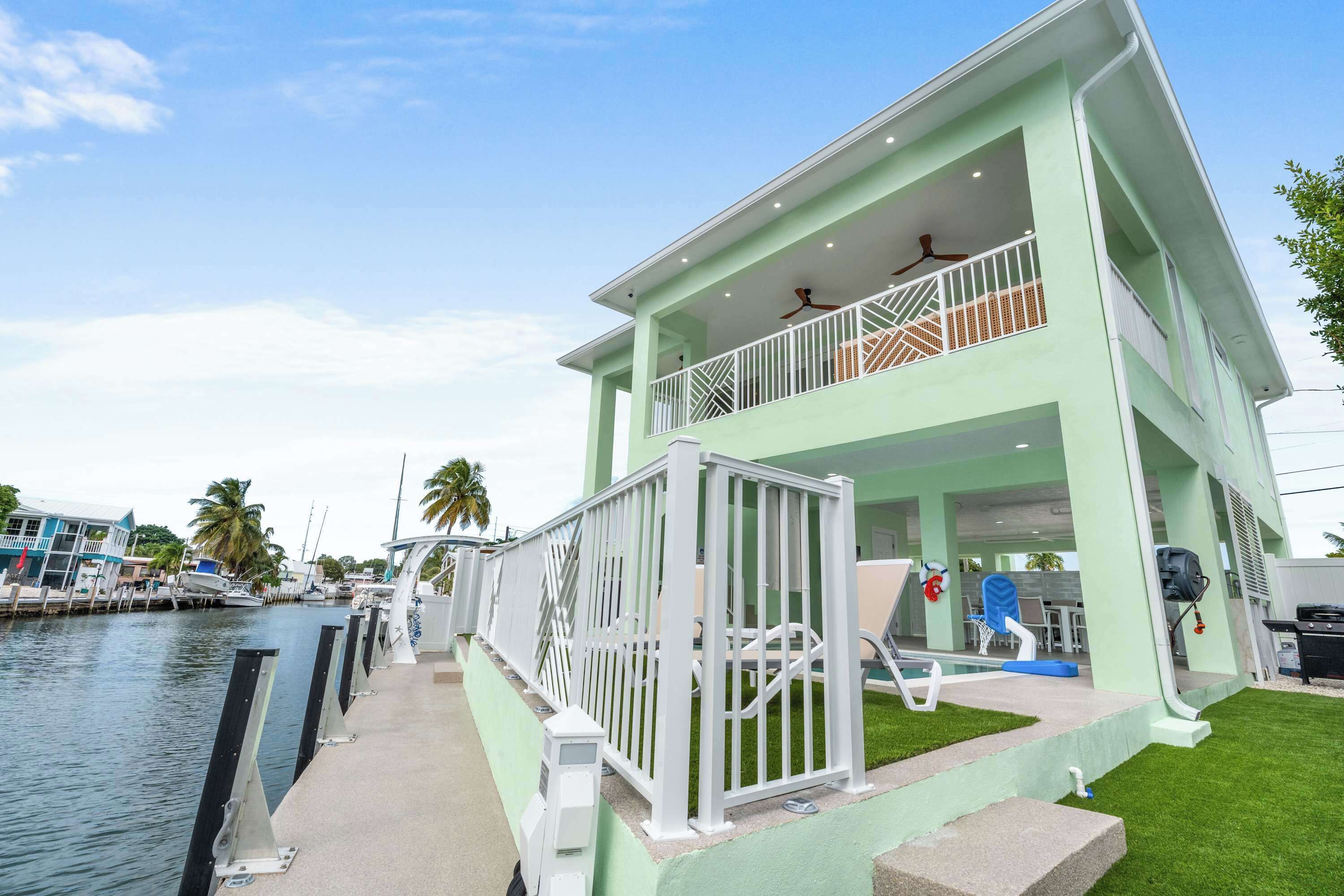 Une propriété de deux étages située au bord de l’eau, dotée d’un balcon, d’une piscine et offrant une vue sur le port de plaisance.