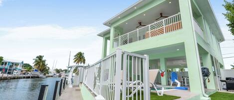 Une propriété de deux étages située au bord de l’eau, dotée d’un balcon, d’une piscine et offrant une vue sur le port de plaisance.