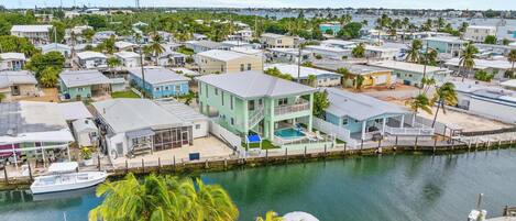 A coastal residential area with houses, a marina, and a clear view of the water.